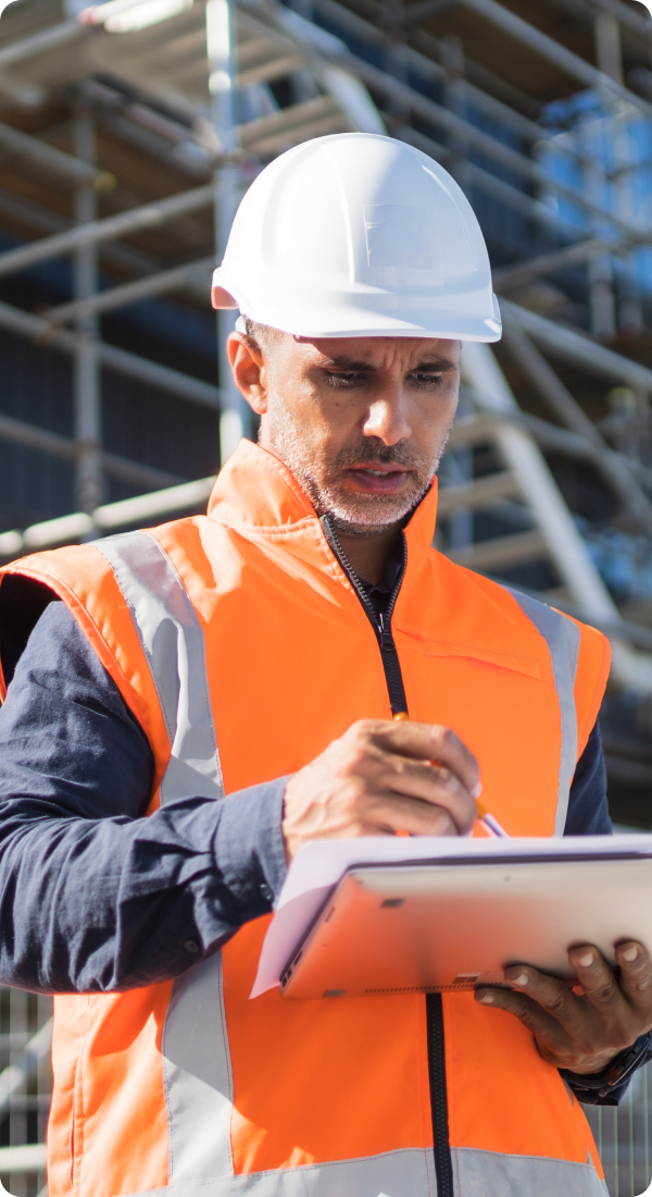 Man in safety vest writing notes